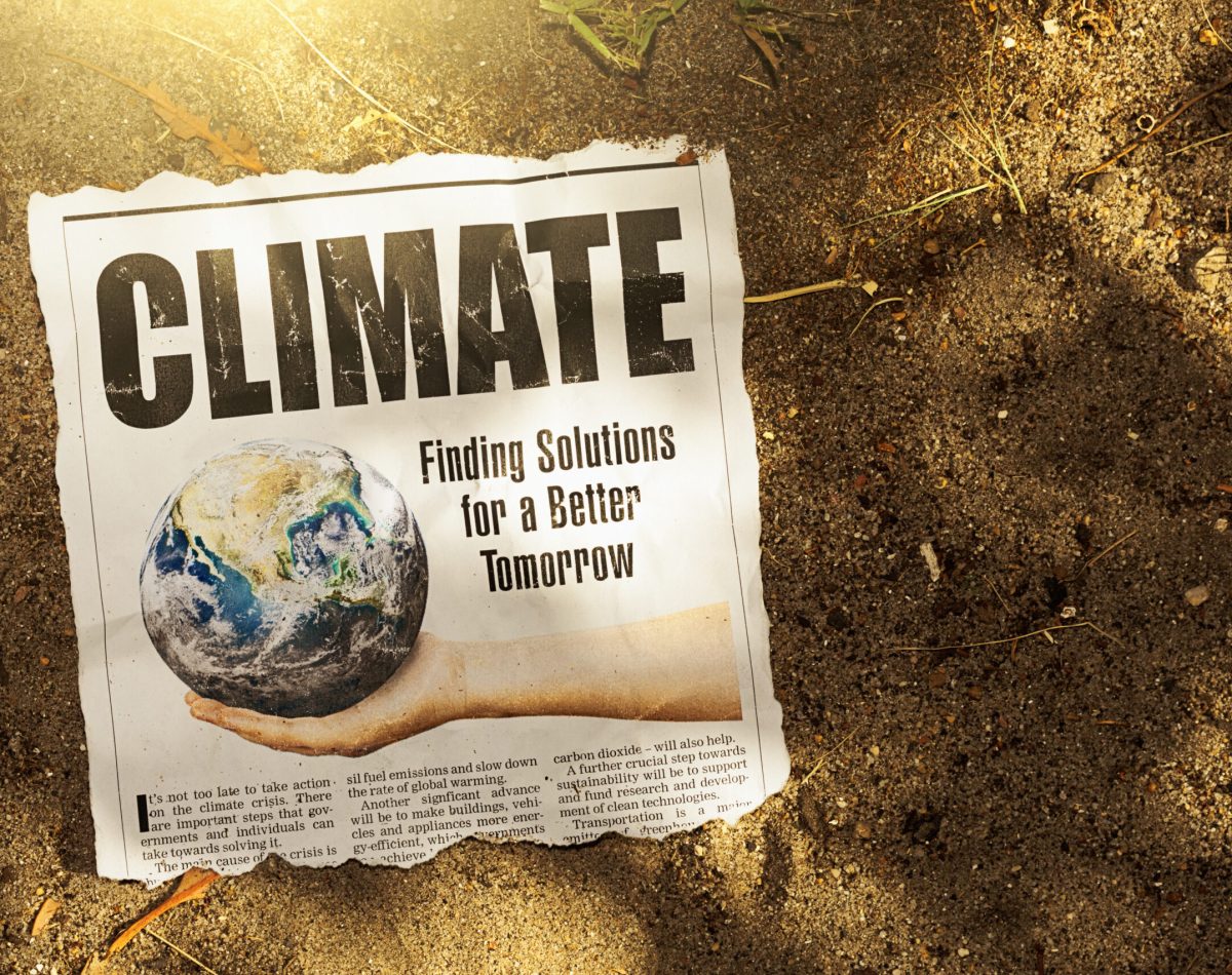 Newspaper clipping about solutions to the climate crisis lies in arid sand in bright sunlight, an image full of irony. Text was written from scratch by the photographer, who also did the design, so this image is free of third-party copyright and may be used without restriction. Public domain satellite Earth image from https://www.nasa.gov/multimedia/imagegallery/image_feature_2159.html